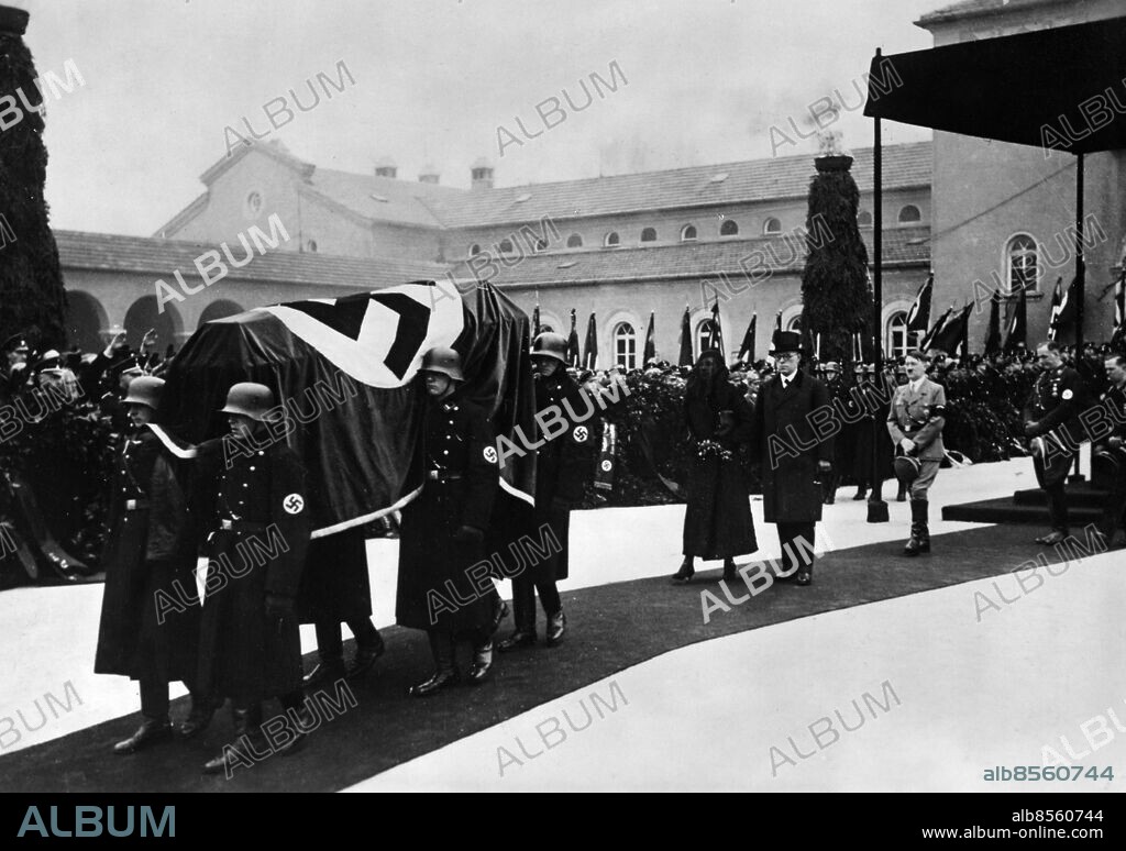 ARKIV TYSKLAND MÜNCHEN 19340124.. Begravning för Paul Ludwig Troost, tysk arkitekt, som bland annat ritat Münchener Braunen Hauses och Haus der Kunst i München och ses som en av de stilbildande arkitekterna för Nazitysklands arkitektur. Här ses kistan, följd av Troosts änka och bror samt rikskansler Adolf Hitler, bäras till graven. Foto: Scherls Bilderdienst / AB Text & Bilder / SVT / Kod: 5600. Tysk originalbildtext. Mapp: Troost, Paul Ludwig. Hakkors.