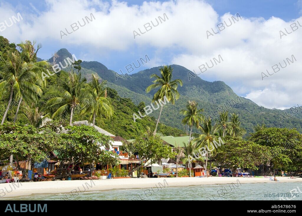 Hat Sai Khao or White Sands Beach is the longest, most popular beach on the island of Ko Chang. It is close to both main piers, Ban Klong Son and Dan Mai, where most of the ferries arrive. In a country blessed with a plethora of beautiful islands, Ko Chang stands out as one of the loveliest. It’s also Thailand’s second largest island (after Phuket), but what makes it so appealing is its rugged aspect, and the way it rises suddenly from the sea, the usual lovely white sand Thai beaches, but backed by a solid hilly interior covered in wild jungle that seems to shelter the coast from the sea. People visit Ko Chang for these pristine beaches, but also for the jungled interior with its many trails and waterfalls, birds, mammals and of course coral reefs. People also seek out Ko Chang because, despite its increasing popularity, it remains a world away from the commercial development of Pattaya, Phuket and Ko Samui – at least for the present. The main beaches are scattered along the western and southern coasts of the island, with the east coast both less accessible and more suited to trekking and bird-watching than swimming and sunbathing. Some of the best coral reefs are to be found around smaller offshore islands, especially to the south and west of the main island. As a general rule, the resort beaches are more developed to the north of the island, and this too is where the most sophisticated restaurants and more up-market accommodations are to be found.