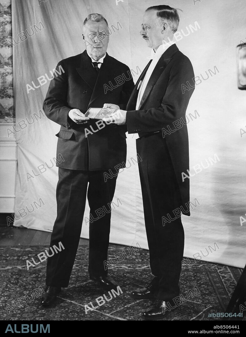 Orig. bildtext... GERMANY'S GRAND OLD MAN OF AVIATION RECEIVES A GOLD MEDAL. Wash., D.C. Dr. Hugo Eckener, the first to pilot a lighter-than-air craft around the world, is given the medal of the National Geographic Society, awarded to but ten other men in forty-two years, but Dr. Gilbert Grosvenor, right, President of the Society. 3/28/30. Anm. H Eckener, 1868-1954, tysk luftskeppskonstruktör, gjorde flera uppmärksammade flygningar med luftskepp, bl a den första jorden runt 1929. G Grosvenor, 1875-1966, redaktör på National Geographic Magazine 1899-1954. Bedrifter Frack Mustascher CD687 persons: GILBERT GROSVENOR;HUGO ECKENER sites: WASHINGTON D C;TYSKLAND*;USA.