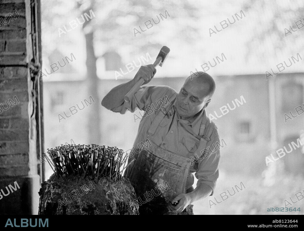 GÜNTHER UECKER. Günther Uecker (* 13.03.1930-), painter, object artist, Germany, nailing in the barn of Pesch Castle in Strümp, a district of Meerbusch. Meerbusch, May 31, 1984.