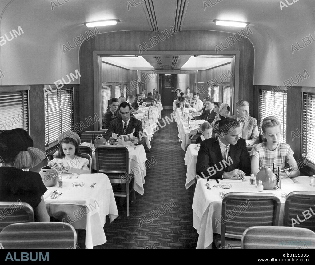 United States:  c. 1940. Passengers on a train in the dining car for dinner.