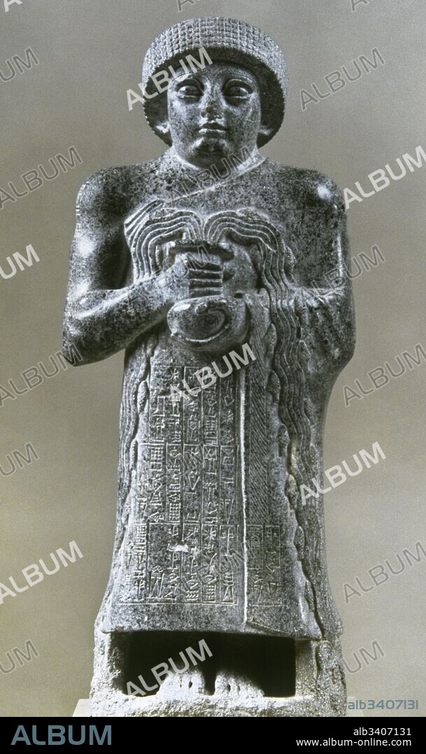 Gudea con el vaso que mana (2141-2122 a. C.). Representa al gobernador de Gudea. Escultura que pertenece al periodo Neo-sumerio. El rey de pie con el manto sumeriano que deja su hombro derecho al descubierto y con la cabeza cubierta por un turbante. Del vaso votivo que sujeta brota agua con peces pequeños. Sobre su vestidura se encuentra grabado un texto en escritura cuneiforme. Siglo XII a. C. Fue tallada en calcita gris o diorita para el templo E-Ninnu, de la ciudad de Ngirsu. Dedicada a la diosa Geshtinanna. Hallada en 1926 en la actual Telloh. Iraq. Museo del Louvre. París. Francia.