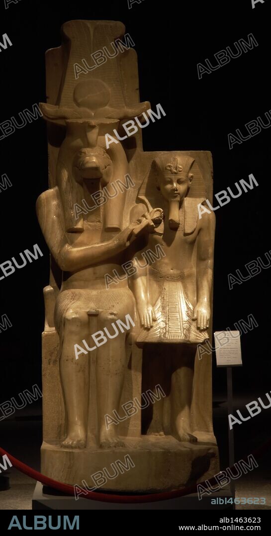Statue of Amenhotep III (Neb-Maat-Ra) and Sobek c.1390-1352 BC. Carved from Calcite (Egyptian Alabaster). Found in the Sobek temple at Dahamsha. Sobek is seated in a human form with the crocodile head and  his right hand holds the Ankh giving life to the youthful Amenhotep III.  The King is wearing the Nemes headdress, with the uraeus and royal beard. 18th Dynasty. New Kingdom. Luxor Museum. Egypt.
