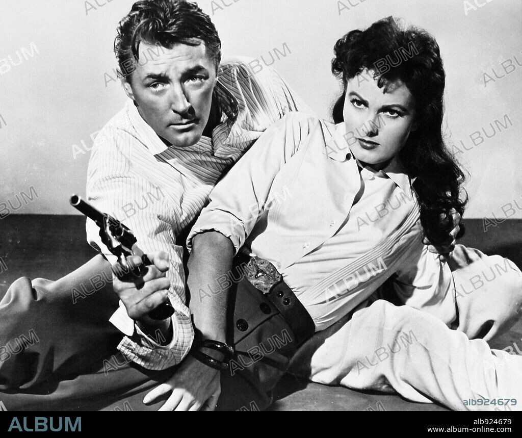 ROBERT MITCHUM and URSULA THIESS in BANDIDO, 1956, directed by RICHARD FLEISCHER. Copyright UNITED ARTISTS.