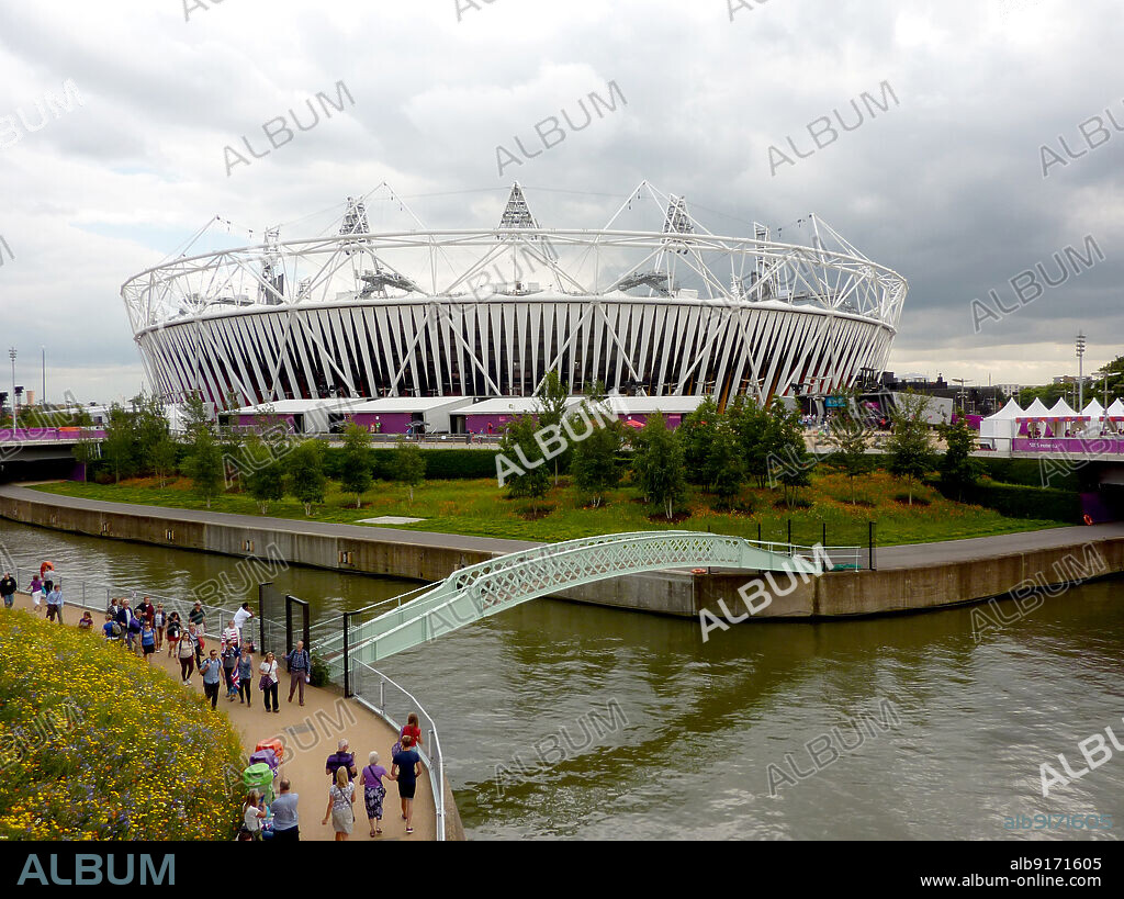 SIMON INGLIS. Olympic Stadium, Queen Elizabeth Olympic Park, Stratford, Newham, Greater London Authority, 2012. The Olympic Stadium in Stratford, seen from the north during the 2012 Summer Olympic Games with a footbridge crossing the River Lea in the foreground.