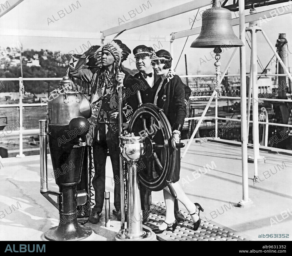 Seattle, Washington, 1928 J.B. Downing, Chief Officer of the American Mail Liner, ""President Grant"", gives Chief Kiutus Tecumseh of the Yakima Tribe, and Miss Leona Wilson, Queen of the Apple Blossoms' Festival, their first lesson in navigation when they visited his ship in Seattle Harbor recently.