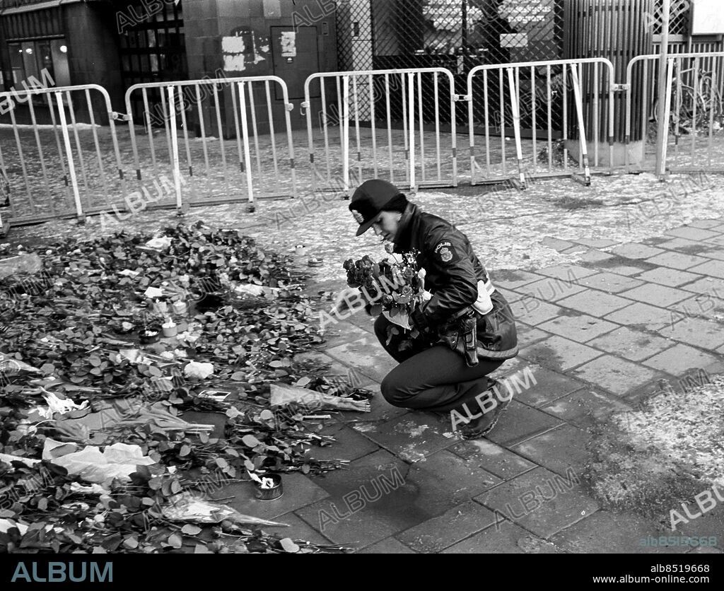 860301. Stockholm.. Mordet på Olof Palme. Polis som lämnar blommor vid mordplatsen. Kravallstängsel.. Foto: GP. ©Kamerareportage *** Local Caption *** . KAMERAREPORTAGE.