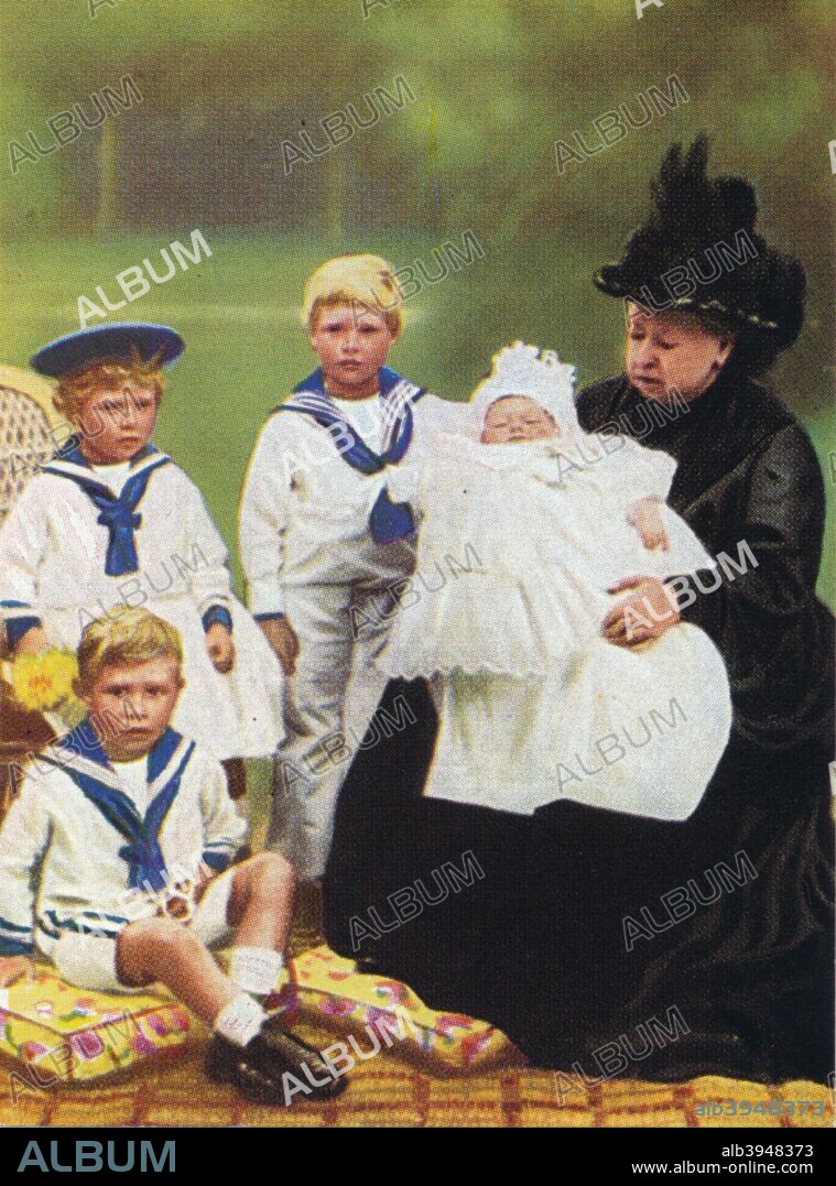 Queen Victoria (1819-1901) at Osborne House on the Isle of Wight, 1900. With the children of the Duke and Duchess of York (later King George V and Queen Mary of Teck). They are Princess Mary (1897-1965) (seated), later Countess Harewood, Prince Edward (standing), later King Edward VIII (1894 - 1972), Prince Albert (on cushion), later King George VI (1895-1952), and Prince Henry, Duke of Gloucester (1900-1974), as a baby. From The Pageant of Kingship cigarette card series, issued by Peter Jackson Ltd., 1937.