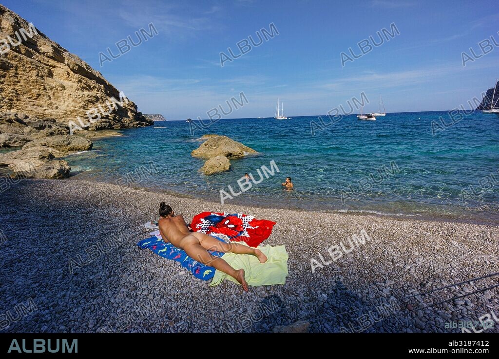 mujer soleandose desnuda,playa de Es Coll Baix,  a los pies del Puig de Sa Talaia, Alcudia,islas baleares, Spain.