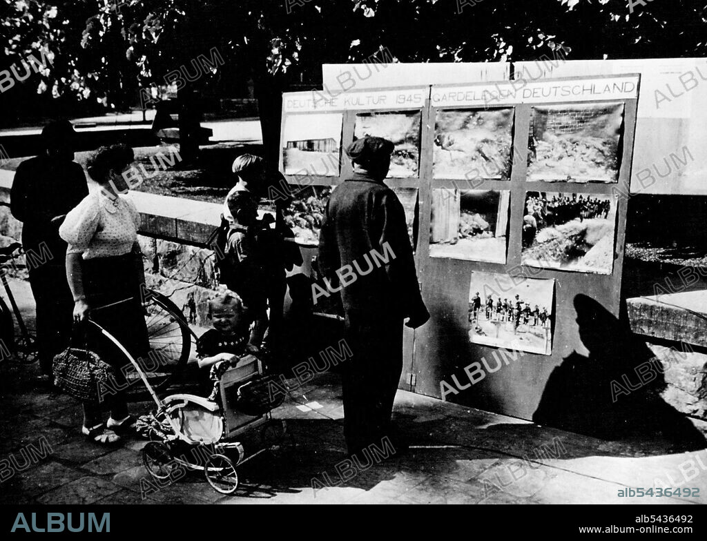 Germans View Atrocities Pictures: Civilians of Beckum, Germany, are shown May 11, 1945, viewing a display of atrocity pictures taken at concentration camps in the Reich immediately after liberation by Allied forces. Beckum is 30 miles northeast of Dortmund. June 13, 1945. (Photo by U.S. Office of War Information Picture).