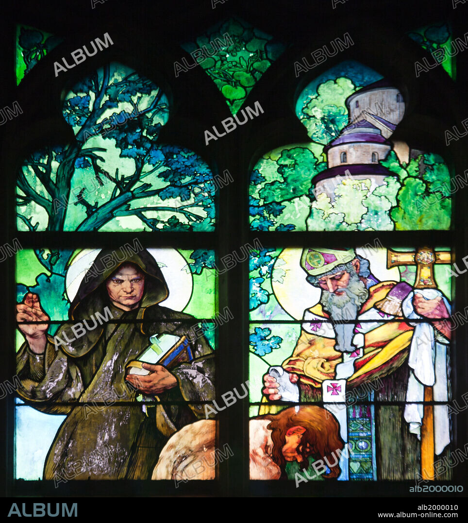 ALPHONSE MUCHA. Prague, St. Vitus Cathedral, Window in the New Archbishop Chapel, Mucha Stained Glass Window. Stained Glass Window, depicting a scene of an allegory of Christ blessing the Slavic nations. Seen are the preachers St. Cyril (the robed monk) and St. Methodius baptizing the kneeling Duke Borivoj. This Art Nouveau painting on glass work was created in 1930.