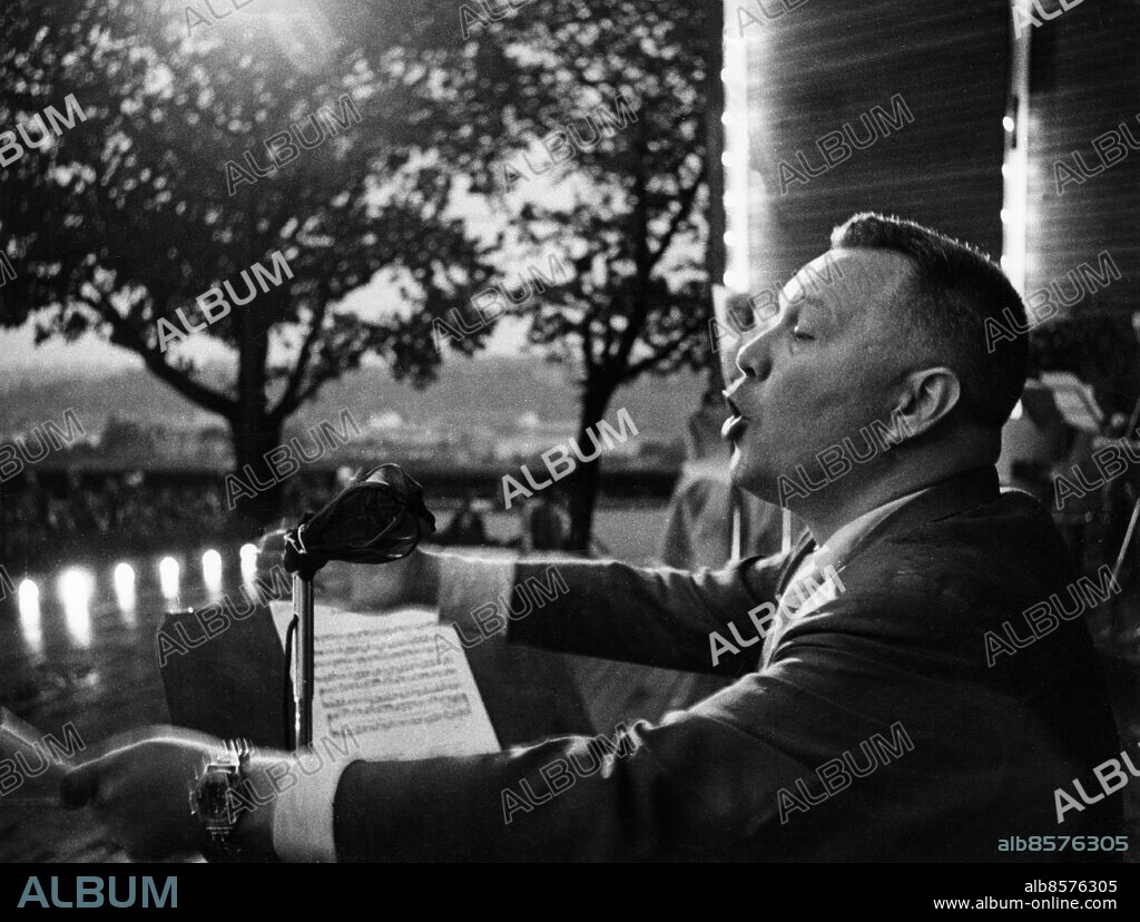 ARKIV STOCKHOLM 19580604.. Egon Kjerrman, kapellmästare, kompositör och arrangör, leder allsång på Skansen i samband med den musikaliska frågeleken "Bäste man på Skansen" som sändes i radio.. Foto: Bertil S-son Åberg / SVT / Kod: 5600. Reportage publ i RiR 22/58 inför radioprogrammet "Bäste man på Skansen" som sändes 1958-06-04 i P 2.. RiR sv/v 14498. Mapp: "Bäste man på Skansen" juni 1958 U 88.