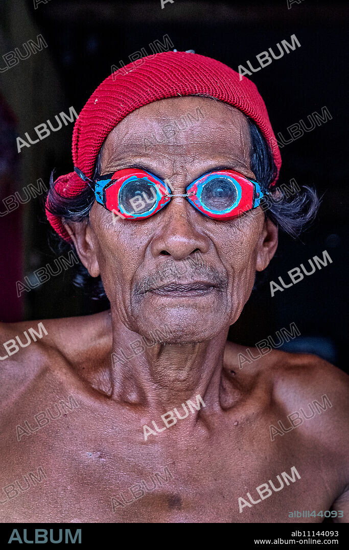 Portrait of a Bajau fisherman wearing crafted wooden goggles from mangrove wood, Togian Island, Indonesia, Southeast Asia, Asia.