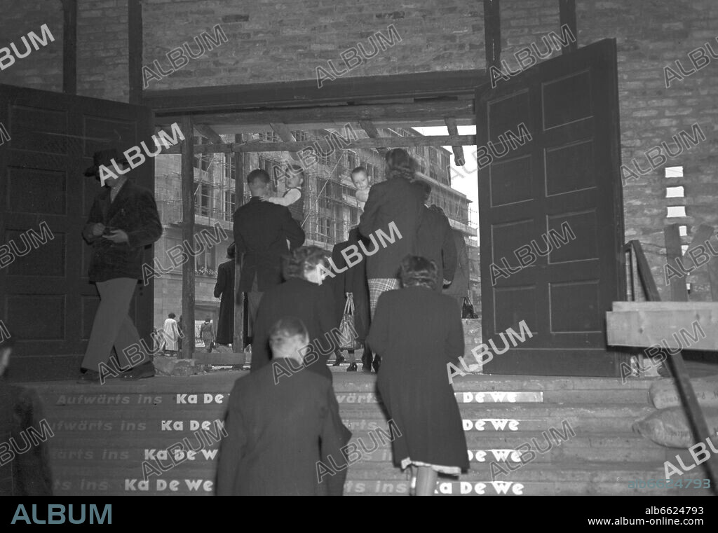 People leaving the subway station Wittenbergplatz towards the Kaufhaus des Westens (KaDeWe, mall of the west), in West Berlin, pictured in 1950. The first two floors of the building, which was seriously damaged during the Second World War, were reconstructed in 1950. The mall was reopened in July 1950. 1950