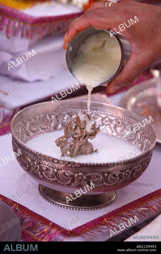 Puja in a Hindu temple, bathing of a statue of goddess Durga with semolina.