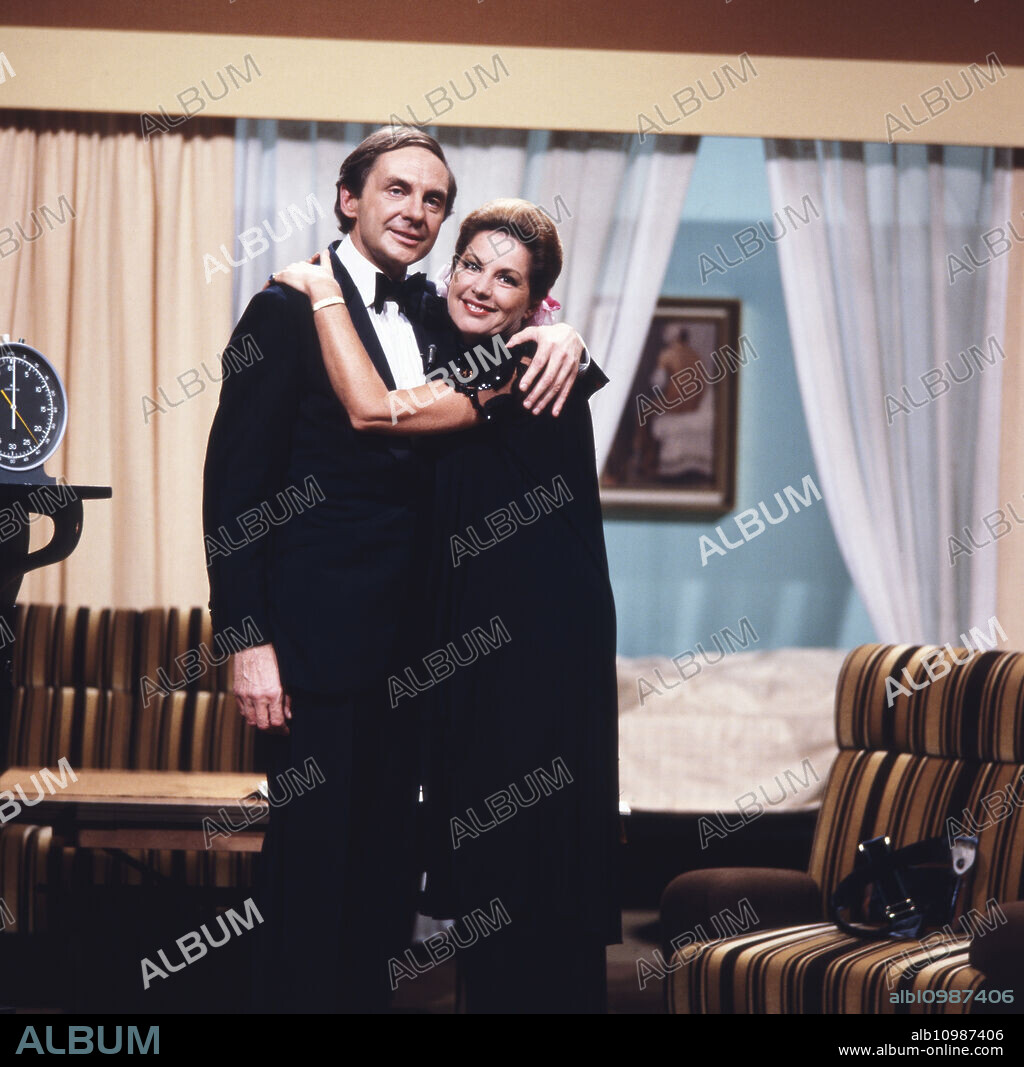 The actor, entertainer and voice actor Harald Juhnke poses with his wife Chariklia Baxevanos in a living room or on a set, Germany 1970s.