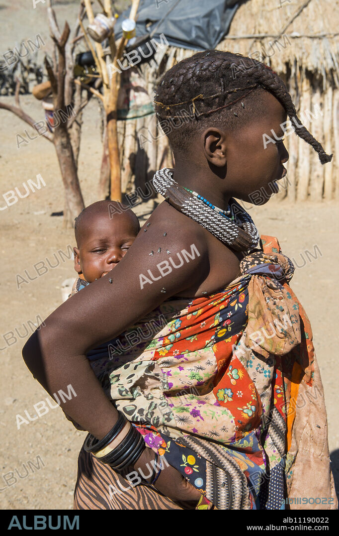 Himba girl carrying a baby, Kaokoland, Namibia, Africa.