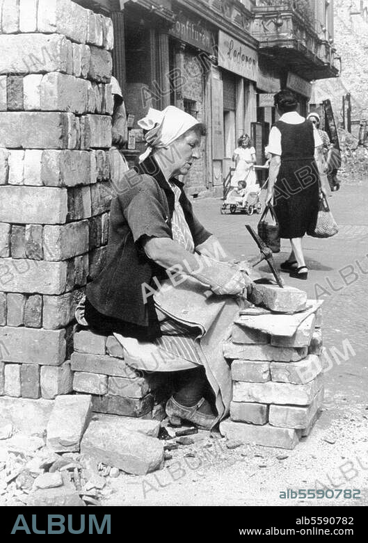"Trümmerfrauen" (Déblayeuses) à Berlin. Obligation pour les femmes de déblayer les ruines (Loi du Conseil de contrôle interallié du 14 janvier 1946). Une "Trümmerfrau" préparant des briques pour le recyclage. Photo.