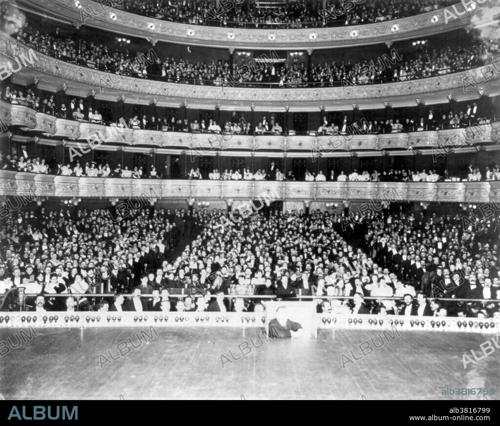Interior of the Metropolitan Opera House, New York, with an audience of over 3,500 People, on the occasion of Max Alvary's 100th Appearance in Wagner's "Siegfried". Sometimes referred to as "the old Met", the Metropolitan Opera House opened on October 22, 1883. It was located at 1411 Broadway, occupying the block between West 39th Street and West 40th Street. Nicknamed "The Yellow Brick Brewery" for its industrial looking exterior, the original Met was designed by J. Cleaveland Cady and had a seating capacity of 3,625. While the theater was noted for its excellent acoustics and elegant interior, as early as the 1900s the backstage facilities were deemed to be severely inadequate for a large opera company. The Met's scenery and sets were a regular sight leaning against the building outside on 39th Street where they had to be shifted between performances. The Met said goodbye to its old house on April 16, 1966, with a farewell performance featuring nearly all of the company's current leading artists. Despite a campaign to preserve the theater, it failed to obtain landmark status and was razed in 1967. Photographed by Ernest Marx, 1888.