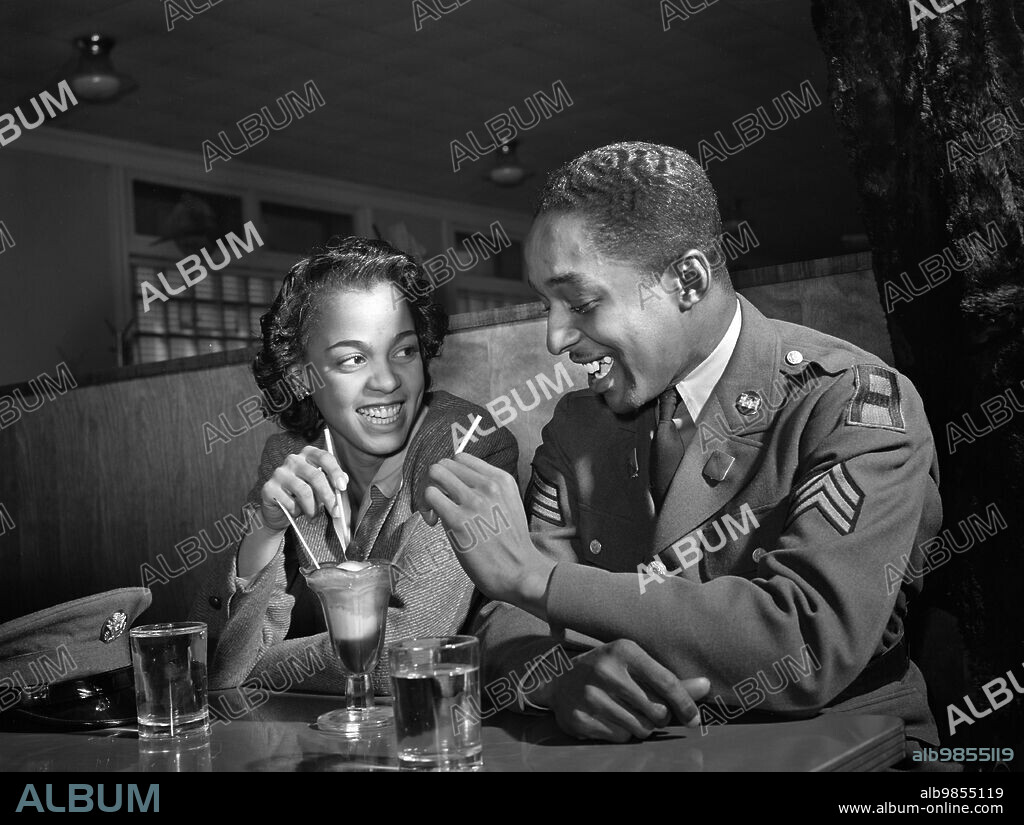 Sergeant Franklin Williams, home on leave from U.S. Army duty, with girlfriend Ellen Hardin, splitting a soda, Baltimore, Maryland, USA, Arthur Rothstein, U.S. Office of War Information. May 1942.
