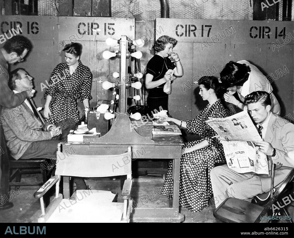German actors Johannes Heesters (l, sitting), Johanna Matz (l, standing), and Hardy Krüger (r, reading) in the make-up room of a film studio in Hollywood. US actress Maggie McNamara sitting on the right of the table. They are shooting the film "The Moon is Blue". 31/01/1953