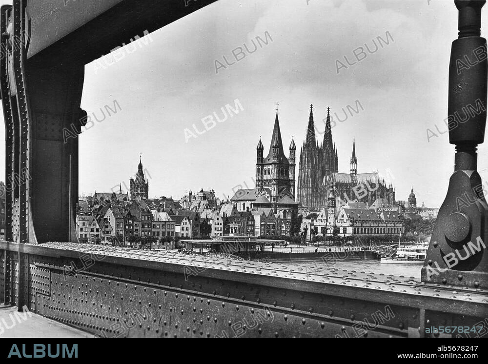 Köln, Dom. (Baubeginn 1248, Weihe des Chors 1322, Vollendung 1842-1880). - Blick von der Hängebrücke auf Dom, Kirche Groß St. Martin und Rathausturm. (v. l. n. r.) - Foto, um 1920.