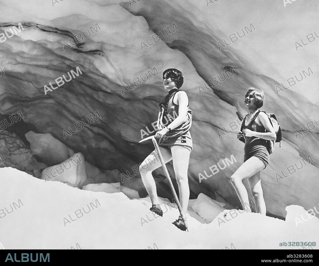 Mount Rainier National Park, Washington:  c.  1928 Two young women in bathing suits and climbing gear hike up to an ice cave under Paradise Glacier.