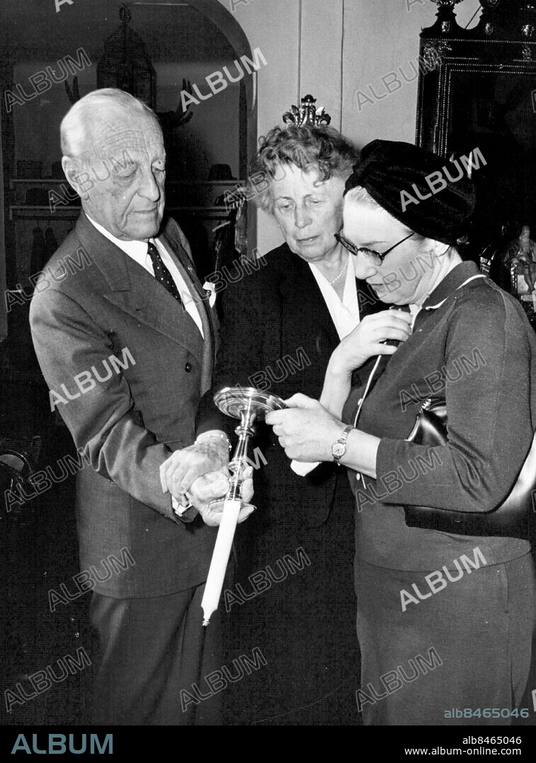 Stockholm 1960-09-28. Rydboholms slott. Här visar friherre Wilhelm von Essen en gammal ljusstake för grevinnan Thora Dardel Hamilton. Mellan dem slottsfrun Lily von Essen. Foto: Gunnar Lantz / SvD / TT / kod 12014.