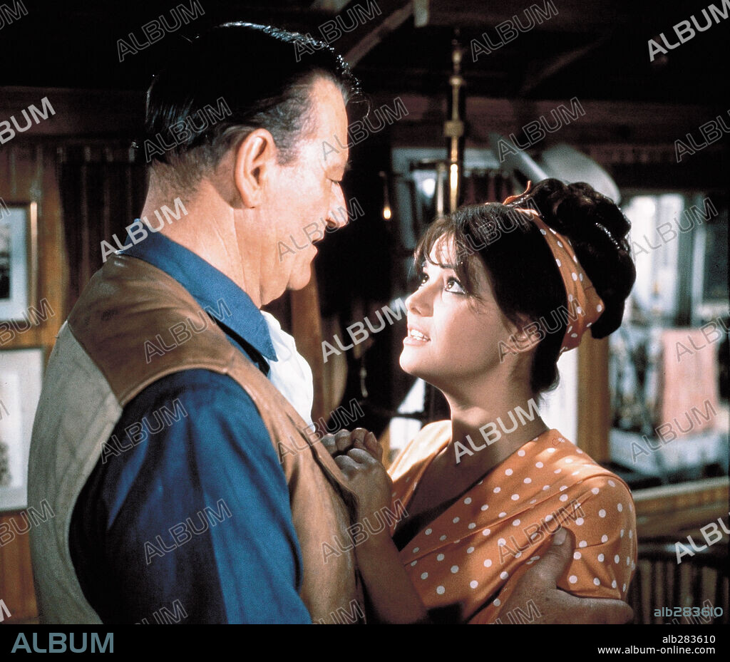 CLAUDIA CARDINALE and JOHN WAYNE in CIRCUS WORLD, 1964, directed by HENRY HATHAWAY. Copyright PARAMOUNT PICTURES.