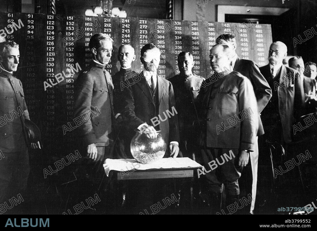 Second Draft. The first number drawn was 246, and was picked from the urn by Secretary of War Baker. June, 1918. In 1917 the administration of Woodrow Wilson decided to rely primarily on conscription, rather than voluntary enlistment, to raise military manpower for WWI. The Selective Service Act of 1917 was carefully drawn to remedy the defects in the Civil War system and, by allowing exemptions for dependency, essential occupations, and religious scruples, to place each man in his proper niche in a national war effort. The act established a liability for military service of all male citizens, and authorized a selective draft of all those between twenty-one and thirty-one years of age (later from eighteen to forty-five);. The Act prohibited all forms of bounties, substitutions, or purchase of exemptions. Administration was entrusted to local boards composed of leading civilians in each community. These boards issued draft calls in order of numbers drawn in a national lottery and determined exemptions. In 1917 and 1918 some 24 million men were registered and nearly 3 million inducted into the military services. Newton Diehl Baker, Jr. (December 3, 1871 - December 25, 1937) was an American politician who belonged to the Democratic Party. He served as the 37th mayor of Cleveland, Ohio from 1912 to 1915 and as U.S. Secretary of War from 1916 to 1921.