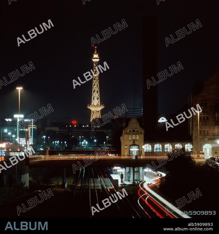 Berlin (West), Bezirk Charlottenburg, S-Bahnhof Messe Nord (Witzleben). Blick von der Brücke Dresselstraße nach Süden auf den S-Bahnhof; im Hintergrund das Messegelände mit dem Funkturm. Nachtaufnahme, undat.
