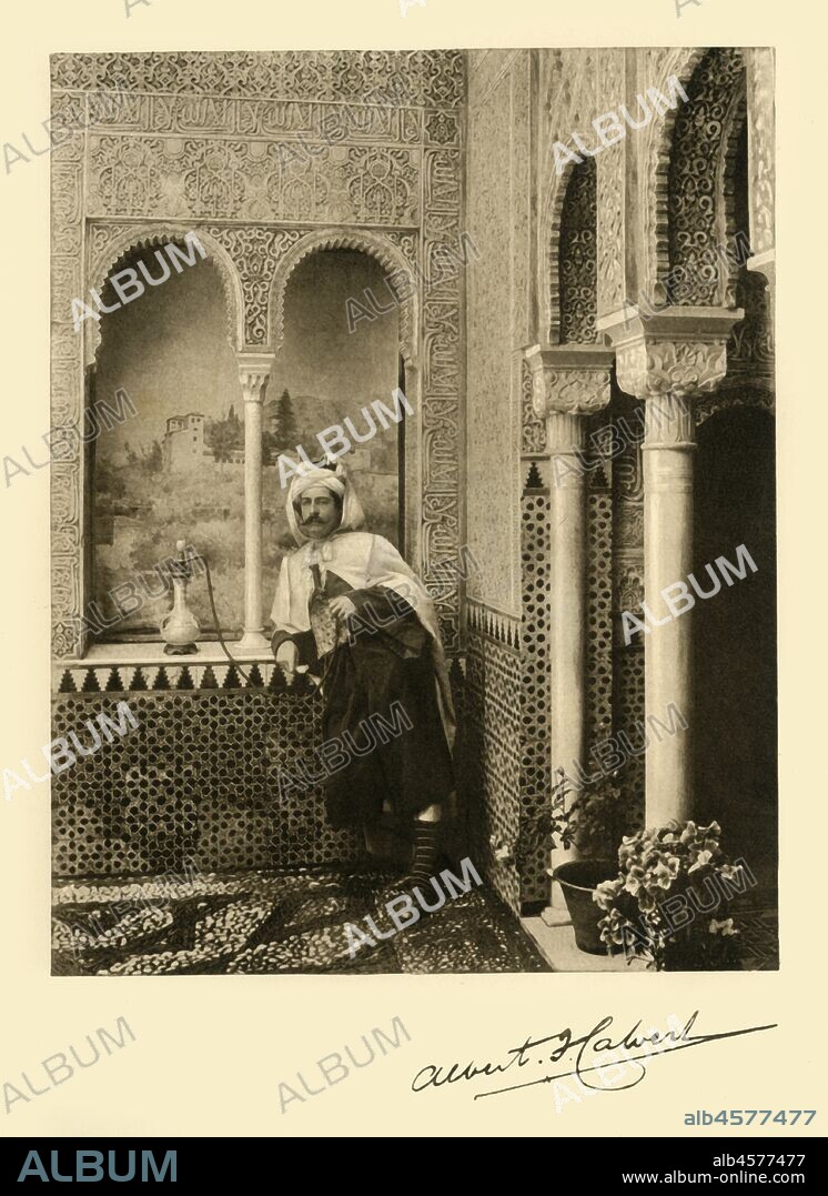 Albert Frederick Calvert in the Alhambra, Granada, Spain, 1907. Portrait of  Australian traveller and author Calvert (1872-1946) wearing 'oriental dress' and smoking a huqqa, in the palace of the Alhambra, which mainly dates from the 14th century. From his "The Alhambra: being a brief record of the Arabian conquest of the Peninsula with a particular account of the Mohammedan architecture and decoration". [John Lane, London & New York, 1907].