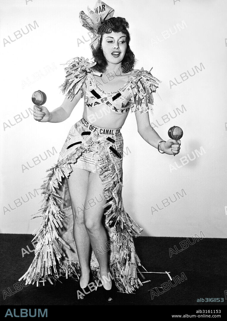 Hollywood, California: c. 1941 Actress Mary Brodel dons her newspaper headlines and performs a War Extra dance with maracas.