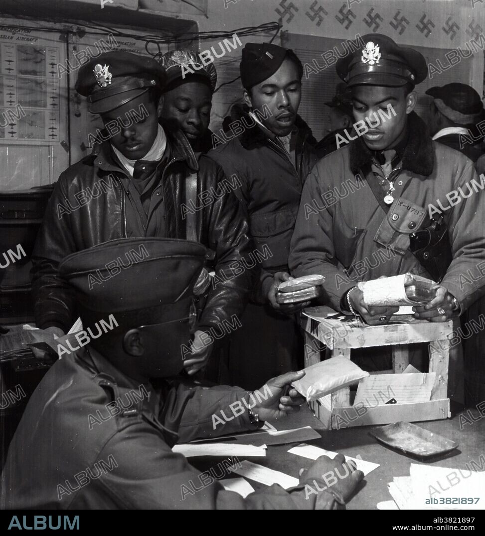 Entitled: "Escape kits (cyanide) being distributed to fighter pilots at air base in southern Italy" shows (seated): Theodore Lumpkin, Jr. Standing (left to right): Joseph Chineworth, Class 44-E; Robert Robinson, Class 44-G; Driskell Ponder, Class 43-I; Robert Williams, Class 44-E. Ramitelli, Italy. The Tuskegee Airmen were the first African-American military aviators in the US Armed Forces. The 332nd Fighter Group operated with the Fifteenth Air Force from May 1944 to April 1945, being engaged primarily in protecting bombers that struck such objectives as oil refineries, factories, airfields, and marshaling yards in Italy, France, Germany, Poland, Czechoslovakia, Austria, Hungary, Yugoslavia, Rumania, Bulgaria, and Greece. They also made successful strafing attacks on airdromes, railroads, highways, bridges, river traffic, troop concentrations, radar facilities, power stations, and other targets. The unit received a Distinguished Unit Citation for a mission on March 24, 1945 when the group escorted B-17s during a raid on the Daimler-Benz tank factory at Berlin, fought the Messerschmitt Me 262 jet interceptors that attacked the formation, and strafed transportation facilities while flying back to the base in Italy. Photographed by Toni Frissell March 1945.