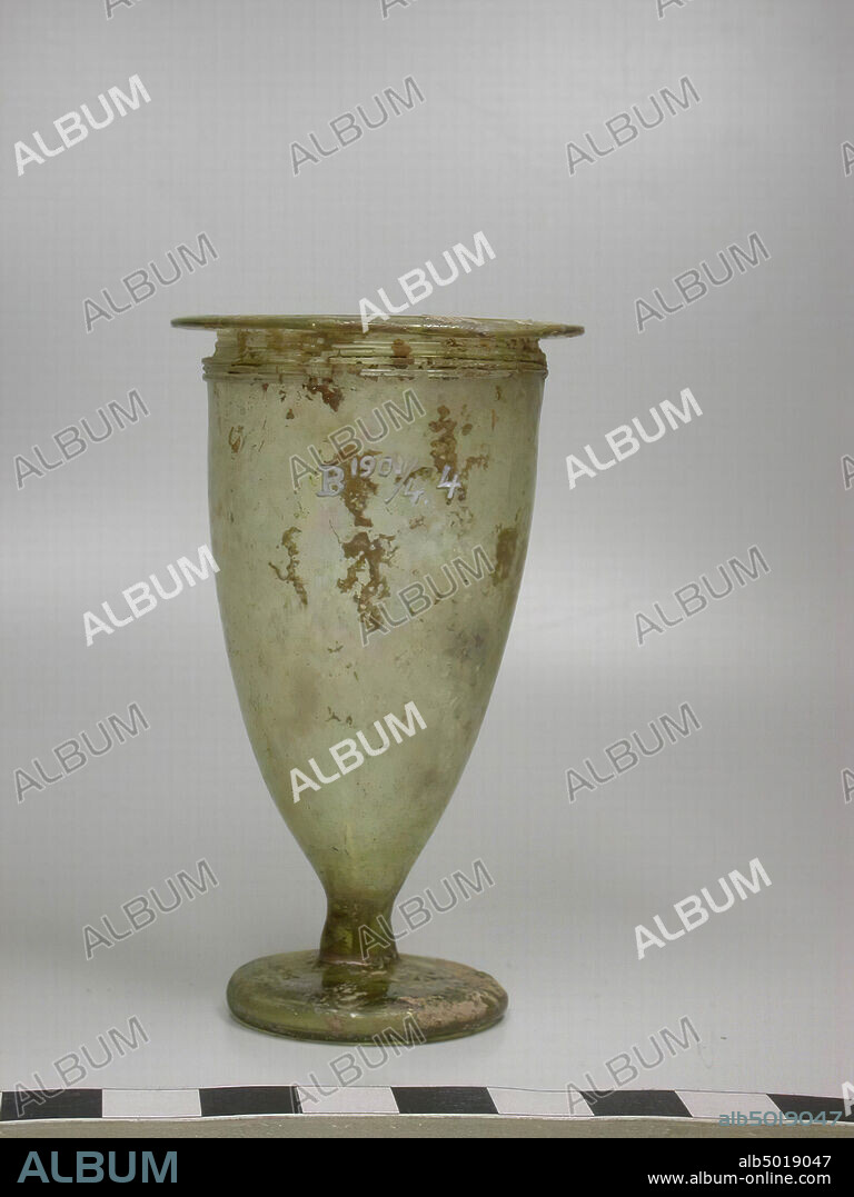 Chalice-shaped cup of yellow-green glass on a small foot. On the mouth a few times with glass thread, tableware, glass, H 8.5 cm, Lebanon.