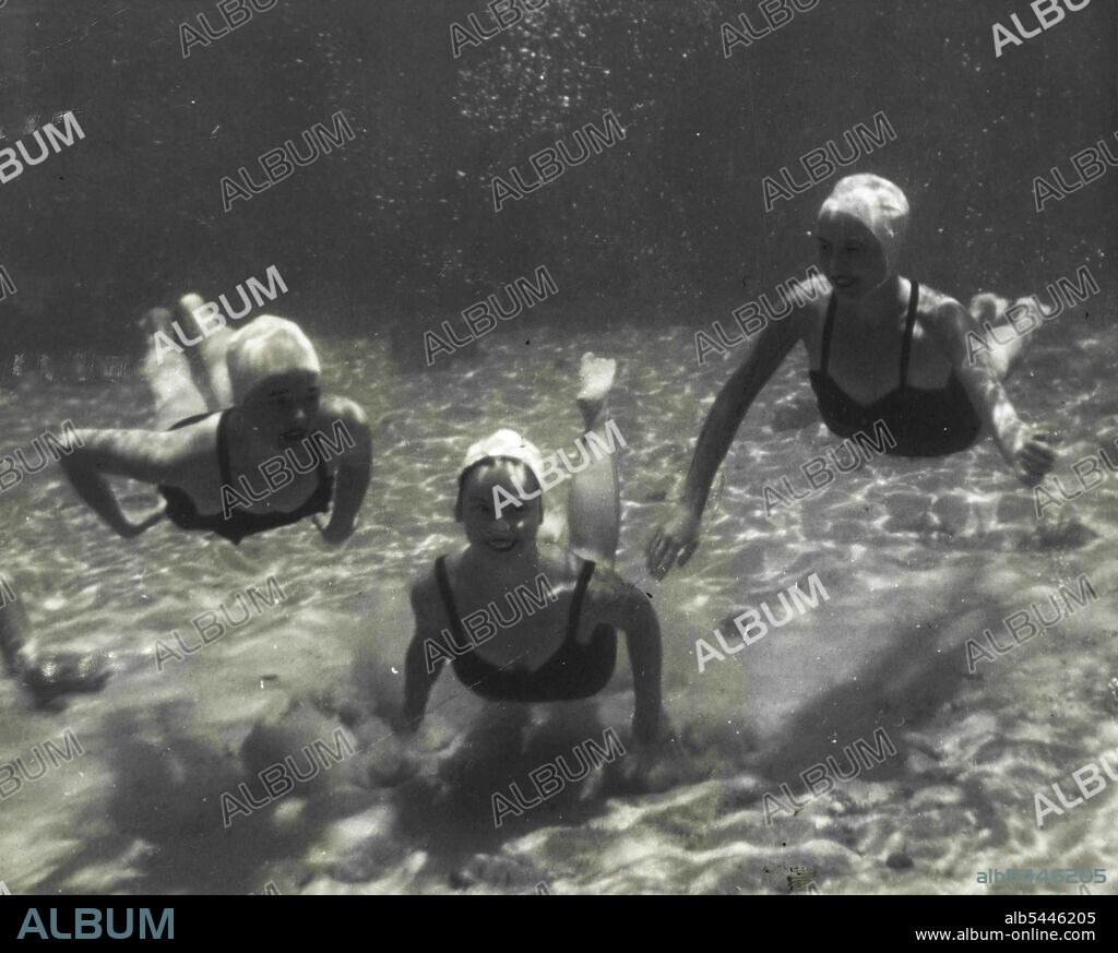 Far-Sighted Swim Suits -- Children's bathing suits also are made of new photo Luminescent Fabric. Here Bebin Drider and Carolyn McCloud display a couple of new models, while Lee Morse shows a grown-up version. The war-born material never looked like this to the GI's who used it overseas. Mermaids -- Fish eye-view of three pretty members of Florida University's Tarpon Club as they glide gracefully through the crystal clear water of Wakulla Springs. June 6, 1947. (Photo by Wide World Photos).