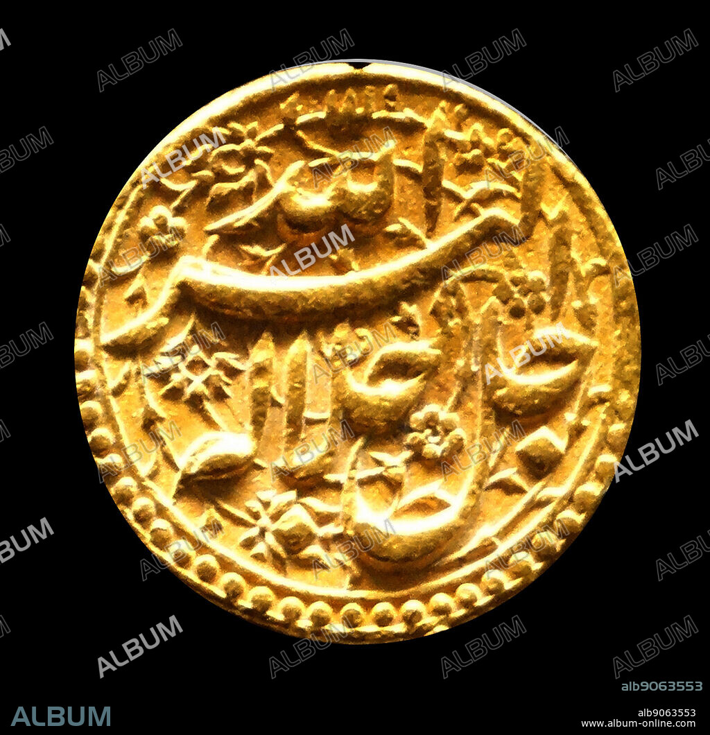 Gold Mughal coin of Emperor Akbar, Agra 1556-1605 This gold coin carries ornate Persian inscriptions which include the names of Persian months.