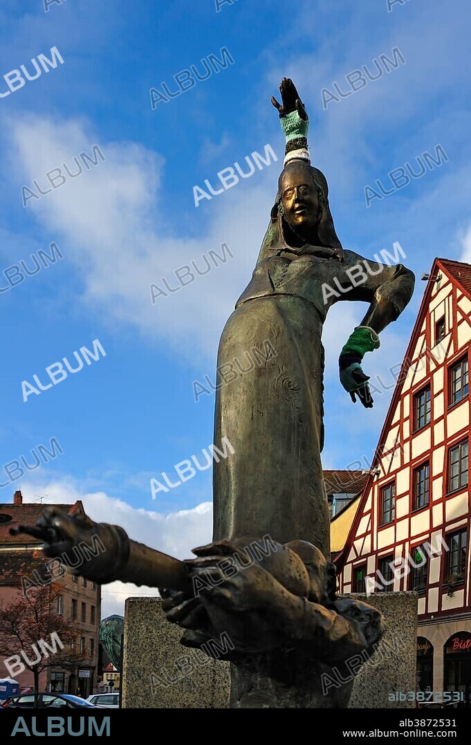 Statues wearing gloves on the Gauklerbrunnen well by artist Harro Frey, an old half-timbered house at the back, Gruener Markt square, historic district, Marktplatz. Altstadt, Fuerth, Middle Franconia, Bavaria, Germany, Europe.