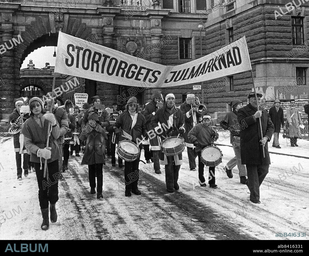 Stockholm 1977-11-19. Julmarknad på Stortorget. Kommunala musikskolans blåsorkester Halvnoten tågade från Sergels torg med modden klafsande kring sulorna.. Foto: Bengt Almquist / DN / TT / Kod: 1. ** SvD OUT **.