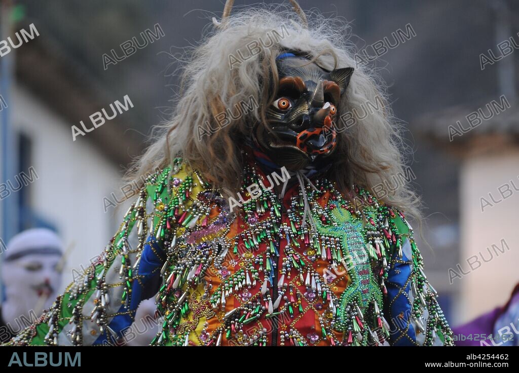 Characters in costumes wearing masks at the annual festival in honor of their patron saint, Mamacha Carmen at Pucartambo, Cusco, Peru. The Virgin Mary is carried in procession through the streets, preceded and followed by traditional dancers of several types, and many festival goers. Traditional dances of the festival include Chukchu, Ch'unchu, Qhapaq negro, Qhapaq Qulla and Saqra.