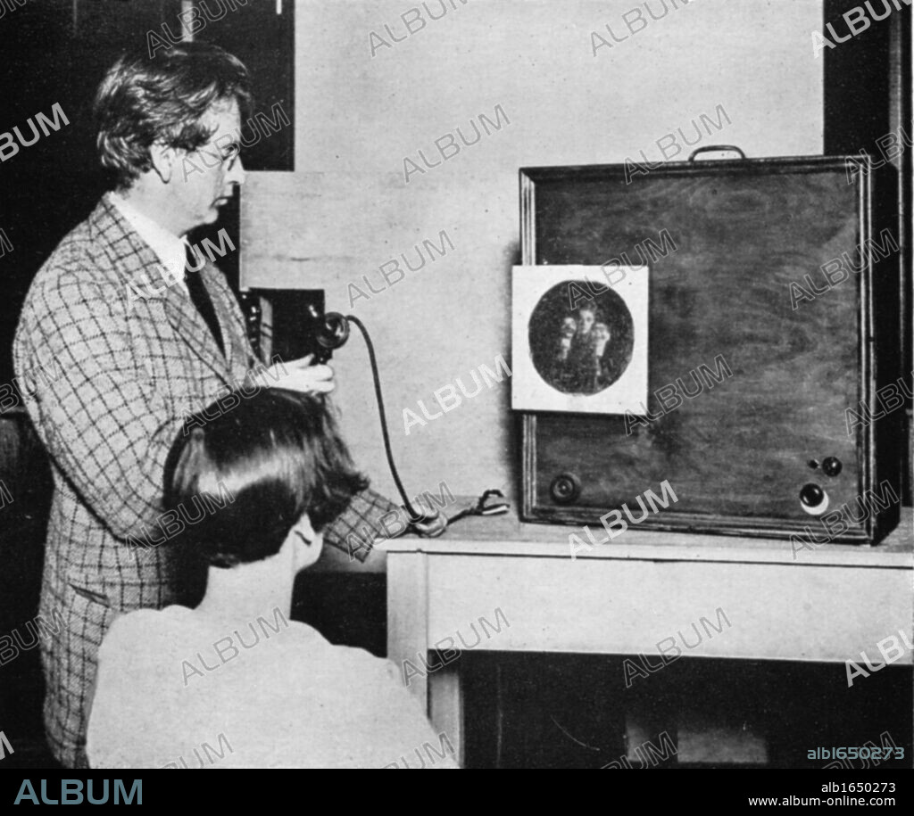 John Logie Baird (1888-1946) Scottish electrical engineer: pioneer of television. Baird in front of an early television ('Seeing by wireless') transmitter.