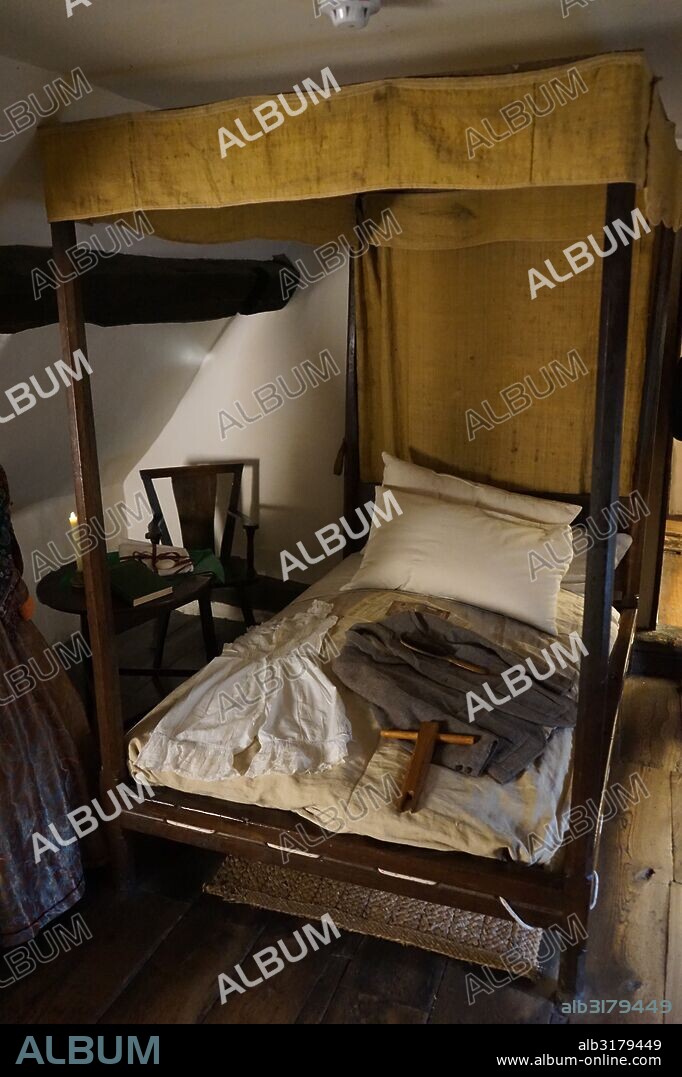 bed with wool jacket at Anne Hathaway's Cottage, where Anne Hathaway, the wife of William Shakespeare, lived as a child. Stratford-upon-Avon, England. The earliest part of the house was built prior to the 15th century; the higher part is 17th century.