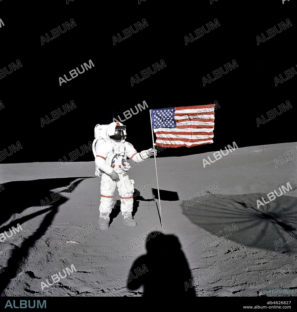Apollo 14 - NASA, 1971. During the first EVA of the Apollo 14 lunar mission in 1971, astronaut Alan B. Shepard stands next to U.S. flag. The shadow of astronaut Edgar D. Mitchell is visible in the foreground.