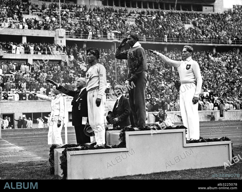 Orig. bildtext... Owens Weitsprung-Olympiasieger mit neuem Weltrekord. Wieder riss der Neger Jesse Owens mit einer Rekordleistung, diesmal im Weitsprung, das Stadion der Hunderttausend zu wahren Jubelstürmen mit: In dieser Disziplin gelang ihm ein Doppelerfolg, krönte er doch diesen seinen zweiten Olympiasieg noch mit dem fantastischen Weltrekord von 8,06 m. Das Bild zeigt die drei besten Weitspringer während der Siegerehrung, im weissen Trainingsanzug der Deutsche Long, der die silberne Medaille errang, Dritter wurde der Japaner Tajima. Anm. Fascisthälsning Hitlerhälsning Längdhopp Sommar-OS v01a Århundradets sportkrönika - del II sänds i SVT1 2000-01-06 persons: Jesse Owens ;Luz Long ;Naoto Tajima sites: BERLIN ;JAPAN* ;TYSKLAND ;USA*.