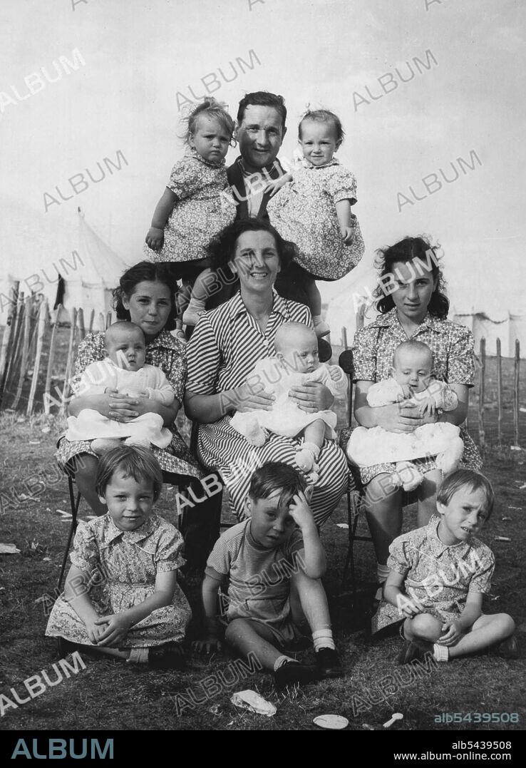 A Treble, Two Doubles, And Three Singles -- Bringing-up twins has its problems but when you have two sets of them, triplets, and three other children, like the Donnellys of Sheerness, then you have a handful. Here Mrs. Donnelly, Mary (12) and Dolores (11) are nursing the six-month-old triplets, Elizabeth, Eileen and Cecilia-they were runners up in a local baby show-while Mr. Donnelly holds Meave and Monica, the 18-month-old twins. In the front Rosaleen and Catherine, aged five, sit with three-ye.