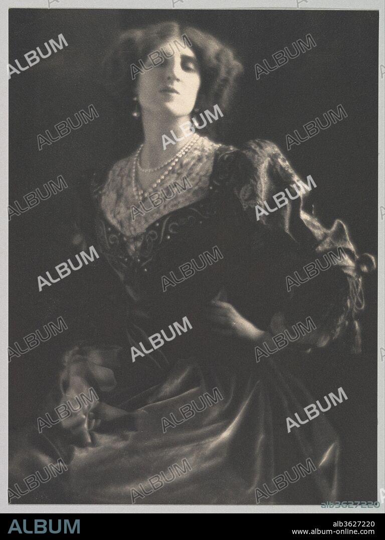[Lady Ottoline Morrell]. Artist: Adolf de Meyer (American (born France), Paris 1868-1946 Los Angeles, California). Dimensions: Image: 23.5 x 17.4 cm (9 1/4 x 6 7/8 in.)
Mount: 43.1 x 35.5 cm (16 15/16 x 14 in.). Date: ca. 1912.
Adolph de Meyer's portrait of Lady Ottoline Morrell, eccentric hostess to Bloomsbury, is a stunning summation of the character of this aristocratic lady who aspired to live "on the same plane as poetry and as music." Rebelling against the narrow values of her class, Lady Ottoline Cavendish Bentinck (1873-1938) married Philip Morrell, a lawyer and liberal Member of Parliament, and surrounded herself in London and on their estate at Garsington with a large circle of friends, including Bertrand Russell, W. B. Yeats, D. H. Lawrence, T. S. Eliot, Katherine Mansfield, Lytton Strachey, Virginia Woolf, Aldous Huxley, and E. M. Forster. Tall, wearing fantastic, scented, vaguely Elizabethan clothes, Lady Ottoline made an unforgettable impression. With her dyed red hair, patrician nose, and jutting jaw, she could look, according to Lord David Cecil, at one and the same moment beautiful and grotesque. Henry James saw her as "some gorgeous heraldic creature--a Gryphon perhaps or a Dragon Volant." 
De Meyer made several portraits of Lady Ottoline. None went as far as this one in conjuring up the sitter's flamboyant persona, capturing, through dramatic lighting and Pre-Raphaelite design, her untamed, baroque quality. "Her long, pale face, that she carried lifted up, somewhat in the Rossetti fashion, seemed almost drugged, as if a strange mass of thoughts coiled in the darkness within her."  D. H. Lawrence's inspired description of the character based on Lady Ottoline in "Women in Love" finds a vivid counterpart in the photographer's art.