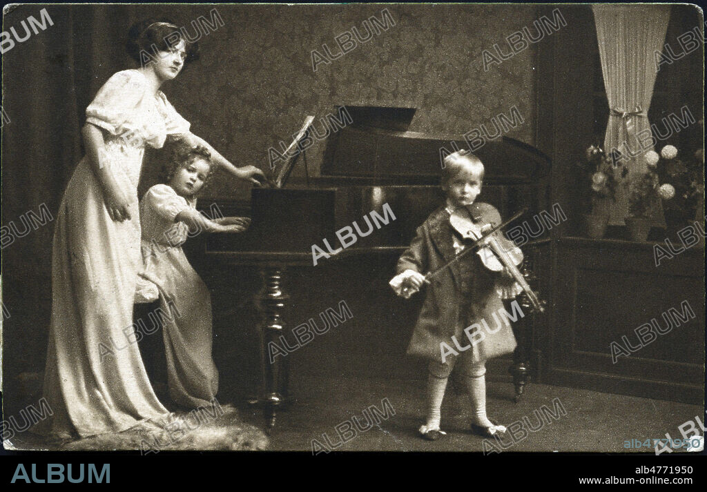 Lecon de musique : une fillette joue du piano, un garcon apprend le violon alto. Photographie anonyme pour une carte postale vers 1905. Credit : Coll. Jonas/KHARBINE-TAPABOR.