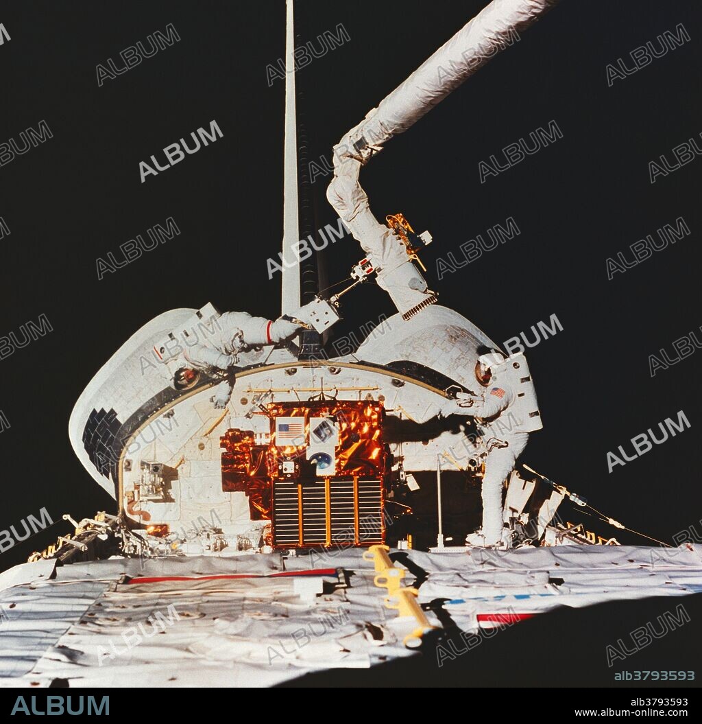Astronaut Michael Foale (red stripe), mission specialist, on the SRMS arm, prepares to grab Spartan 204 as astronaut Bernard Harris Jr., payload commander, looks on. STS-63 flew from 2/3/95 - 2/11/95.