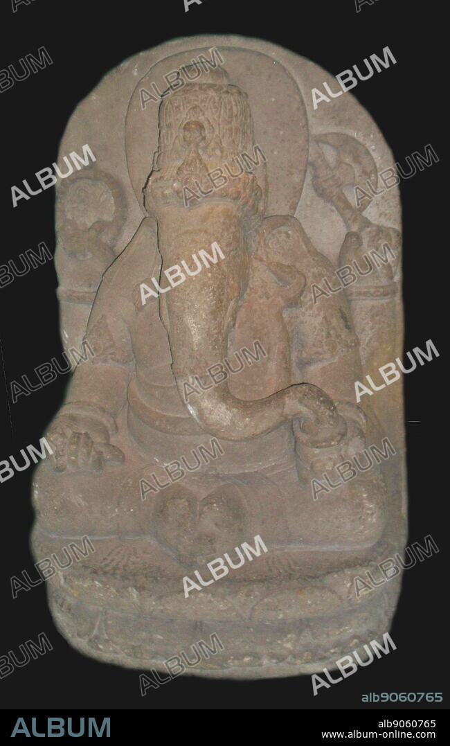 The Hindu god Ganesha (the elephant god). In his right hand the god of wisdom holds aset of prayer beads and his broken tusk. The left hand holds an axe and a bowl of sweetmeats. Eastern Javanese andesite stone sculpture. Indonesia. 13th century.
