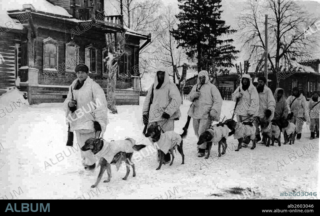 Image shows Soviet soldiers with explosives-laden Anti-Tank Dogs walking through the snow. Taken during the Battle of Moscow, 1941.